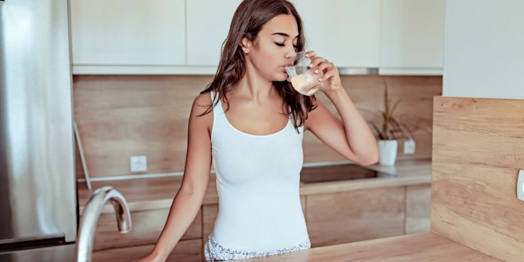 Woman in rental property drinking filtered water